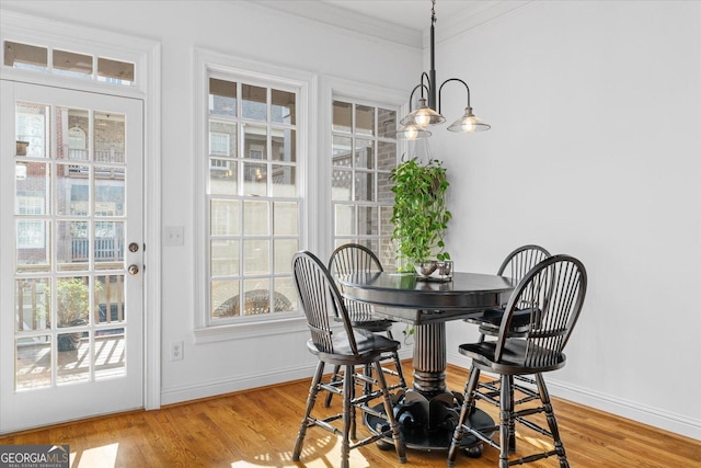 dining room with crown molding, a chandelier, and light wood-type flooring