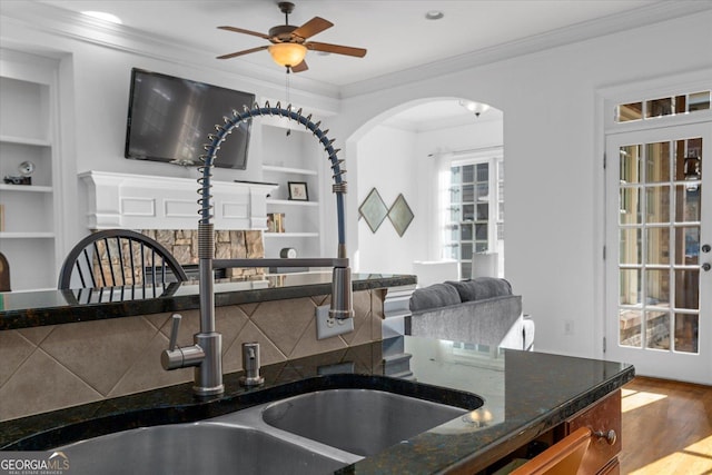 kitchen featuring crown molding, tasteful backsplash, built in features, hardwood / wood-style flooring, and ceiling fan