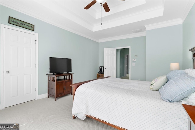 carpeted bedroom featuring crown molding, ceiling fan, and a tray ceiling