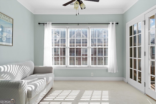 living area featuring crown molding, light carpet, and ceiling fan