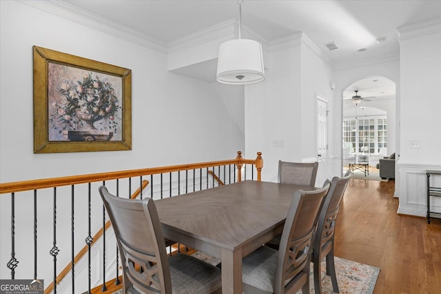 dining room with hardwood / wood-style floors, ornamental molding, and ceiling fan