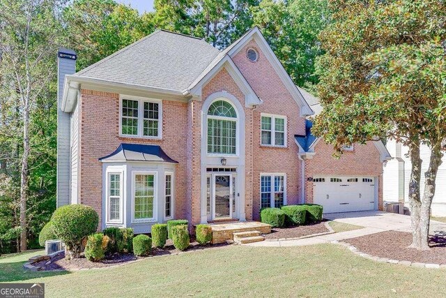 view of front of home featuring a garage, central AC, and a front yard