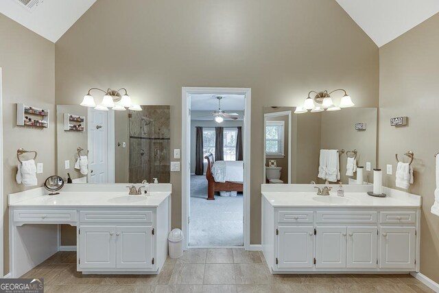 bathroom featuring vanity, high vaulted ceiling, and tiled shower