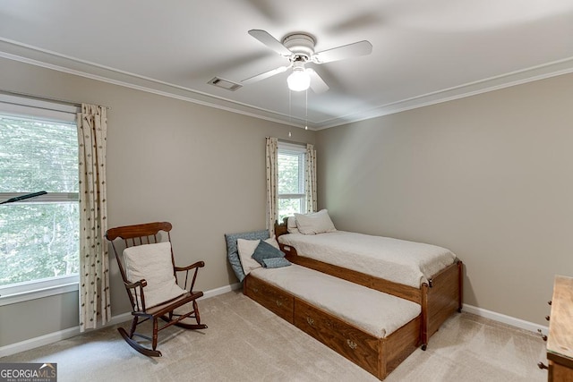 bedroom with ceiling fan, ornamental molding, and light carpet