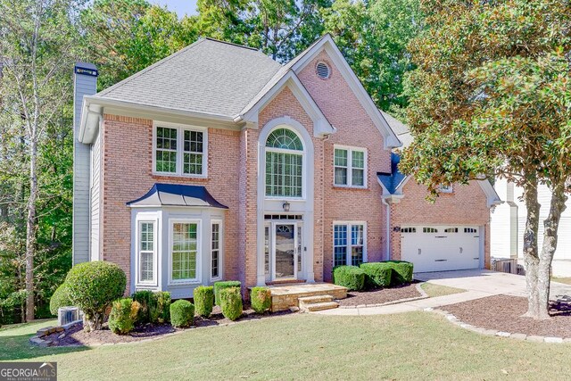 view of front of home featuring central AC, a garage, and a front lawn