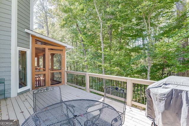 wooden deck with area for grilling and a sunroom