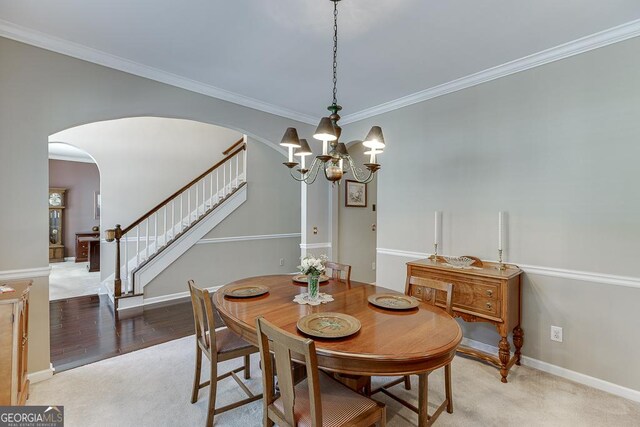 carpeted dining space with an inviting chandelier and crown molding