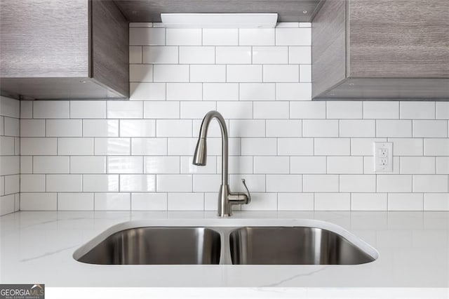 room details featuring light stone countertops and sink