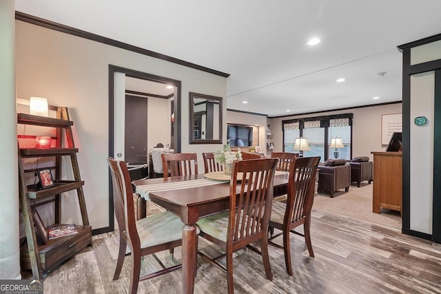 dining space with hardwood / wood-style flooring and crown molding