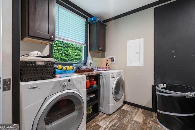 washroom with wood-type flooring, cabinets, ornamental molding, washing machine and clothes dryer, and electric panel