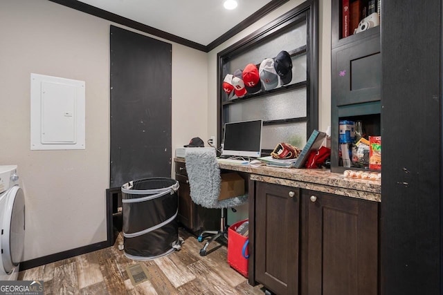 home office with built in desk, washer / clothes dryer, electric panel, crown molding, and light hardwood / wood-style flooring