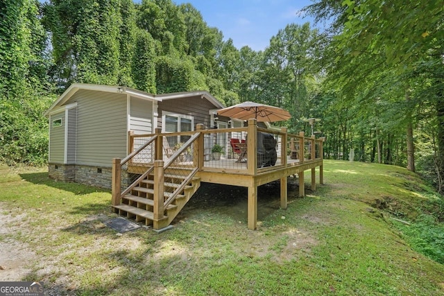 rear view of house with a wooden deck and a yard