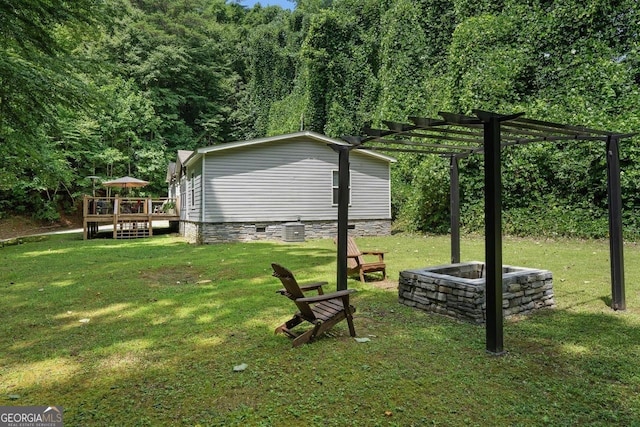 view of yard featuring a pergola, a fire pit, and a deck