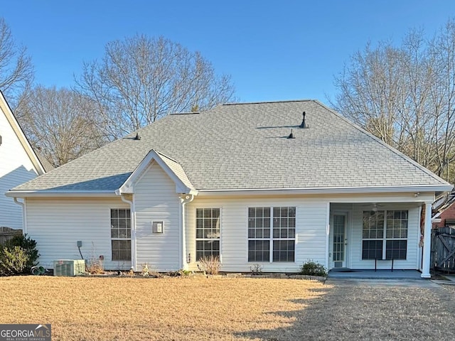 back of house featuring a shingled roof, a lawn, and a porch