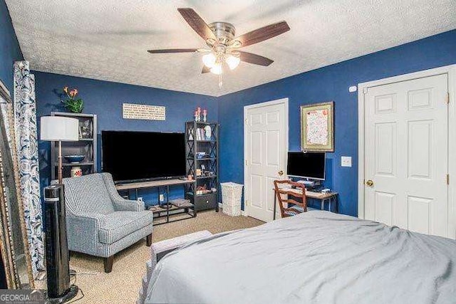 carpeted bedroom featuring ceiling fan and a textured ceiling