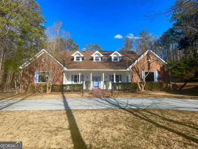 cape cod house featuring a front lawn