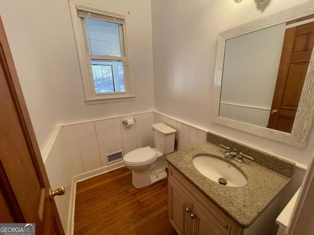 bathroom featuring vanity, wood-type flooring, and toilet