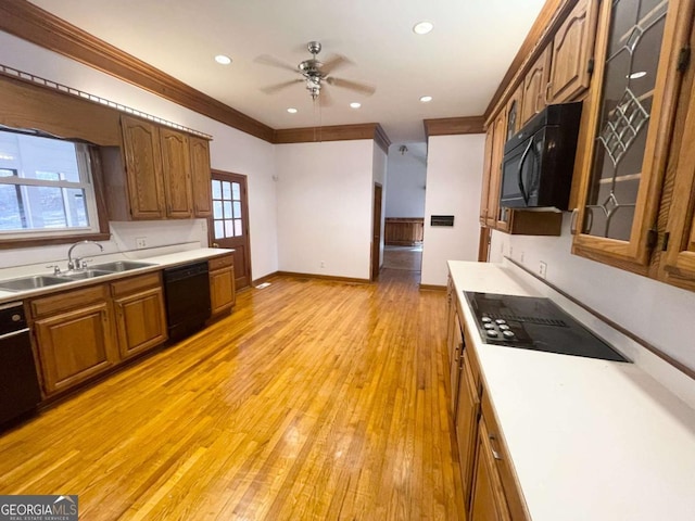 kitchen with sink, light hardwood / wood-style flooring, ornamental molding, ceiling fan, and black appliances