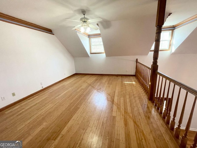 additional living space featuring lofted ceiling, ceiling fan, light hardwood / wood-style floors, and a healthy amount of sunlight