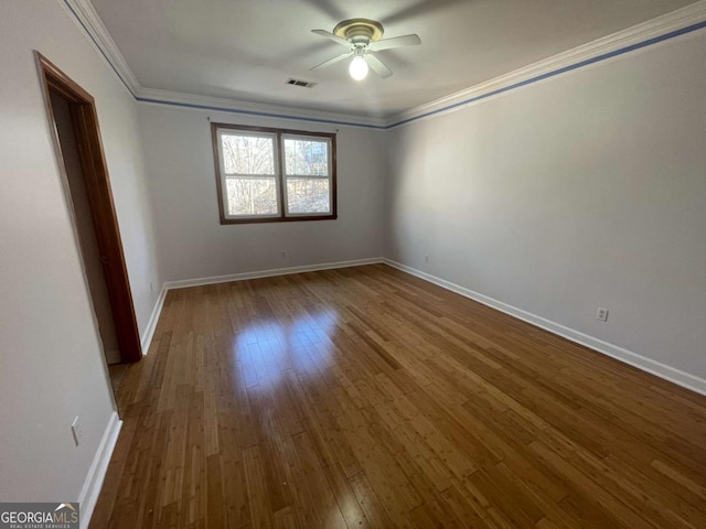 empty room featuring hardwood / wood-style flooring, crown molding, and ceiling fan