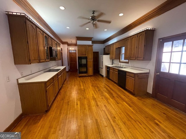 kitchen featuring sink, crown molding, ceiling fan, light hardwood / wood-style floors, and black appliances