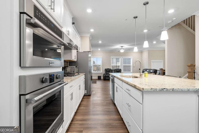 kitchen featuring sink, decorative light fixtures, an island with sink, and appliances with stainless steel finishes