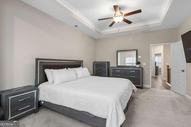 carpeted bedroom featuring ceiling fan, ornamental molding, and a tray ceiling