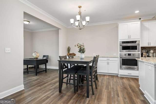 dining area featuring dark wood-type flooring, ornamental molding, and a chandelier