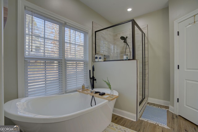 bathroom featuring hardwood / wood-style floors and plus walk in shower