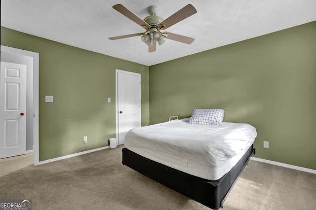 carpeted bedroom with ceiling fan and a textured ceiling