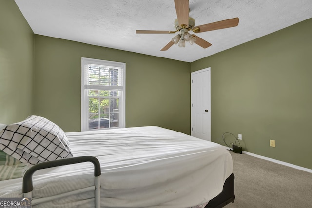 carpeted bedroom with ceiling fan and a textured ceiling