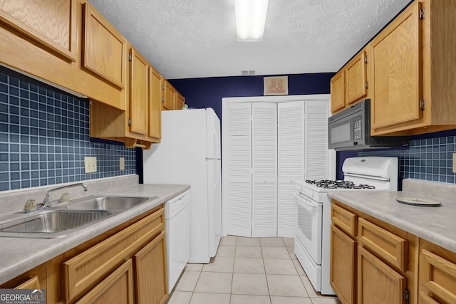 kitchen with sink, white appliances, light tile patterned floors, and backsplash