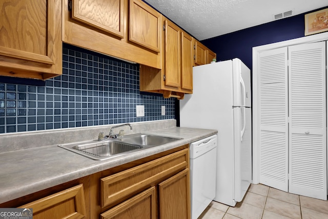 kitchen featuring light tile patterned flooring, sink, tasteful backsplash, a textured ceiling, and dishwasher