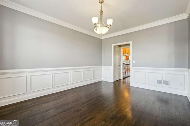 spare room with an inviting chandelier, dark wood-type flooring, and ornamental molding