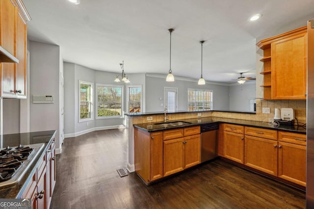 kitchen with sink, tasteful backsplash, decorative light fixtures, kitchen peninsula, and stainless steel appliances