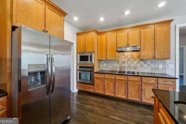 kitchen with tasteful backsplash, dark wood-type flooring, stainless steel appliances, and dark stone counters