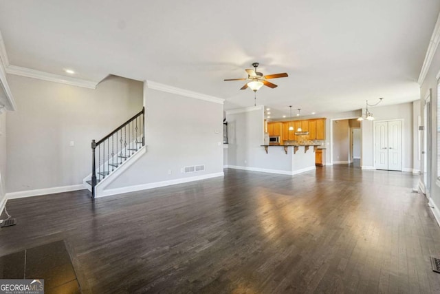 unfurnished living room featuring ornamental molding, dark hardwood / wood-style floors, and ceiling fan with notable chandelier