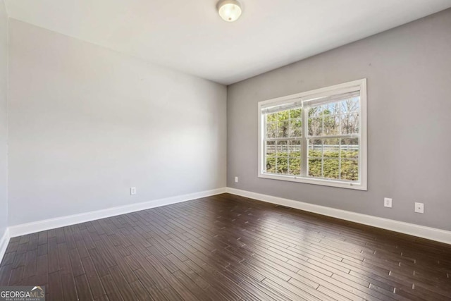 empty room with dark hardwood / wood-style flooring