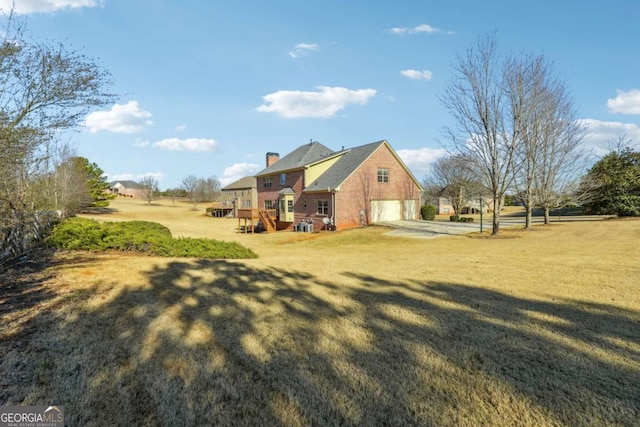 view of property exterior with a garage, a wooden deck, and a yard