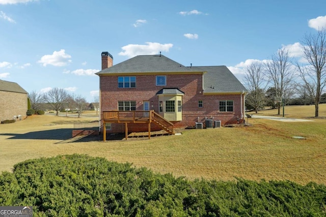 rear view of property with a wooden deck, central air condition unit, and a lawn