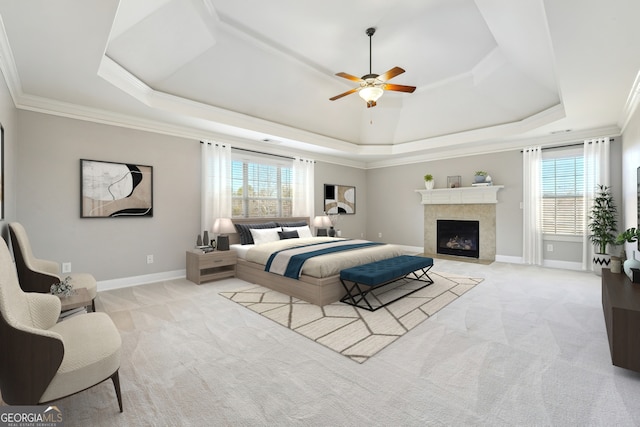 carpeted bedroom with a raised ceiling, crown molding, and a tiled fireplace