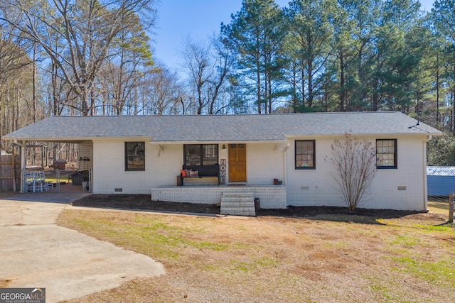 single story home with a front lawn, a carport, and covered porch