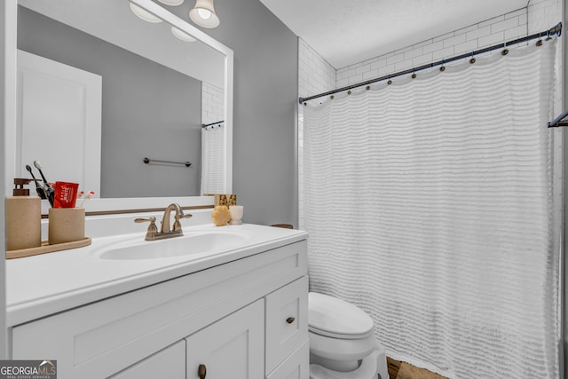 bathroom featuring a shower with curtain, vanity, toilet, and a textured ceiling