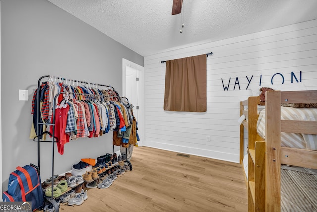 walk in closet featuring wood-type flooring and ceiling fan