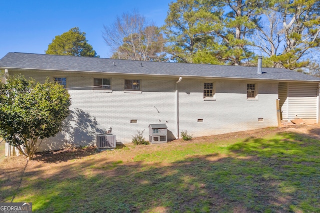 back of property with a yard and central AC