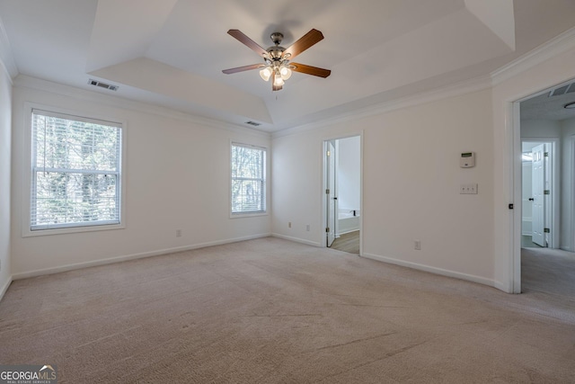 carpeted empty room with crown molding, a raised ceiling, and ceiling fan