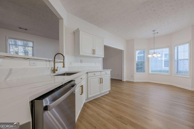 kitchen featuring sink, white cabinetry, a textured ceiling, stainless steel dishwasher, and light hardwood / wood-style floors