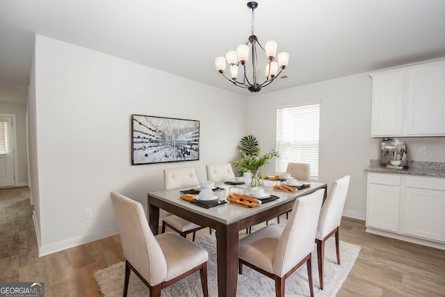 dining area featuring a chandelier and light hardwood / wood-style floors