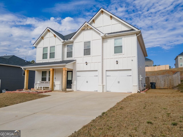 view of front of property featuring a garage, a front lawn, and covered porch