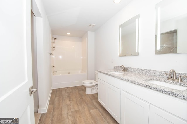 full bathroom with vanity, hardwood / wood-style flooring, bathing tub / shower combination, and toilet